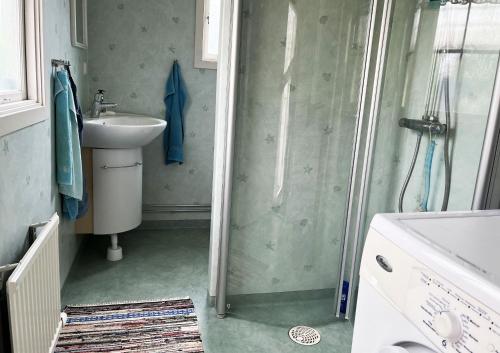 La salle de bains est pourvue d'une douche, d'un lavabo et de toilettes. dans l'établissement Cozy cottage close to Farjestaden, à Färjestaden