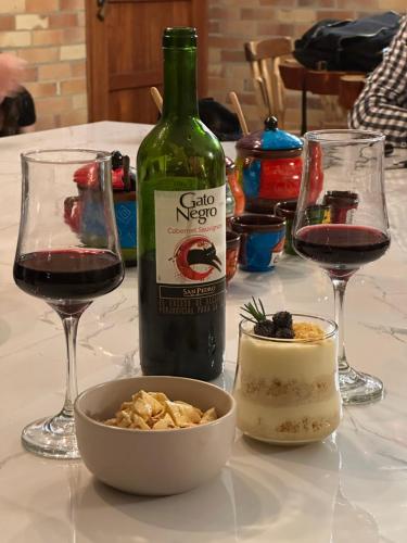 a bottle of wine and a bowl of food on a table at Glamping Shalom in Choachí