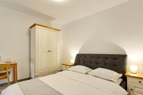 a bedroom with a large white bed with two lamps at Casa Alma in Vişeu de Sus