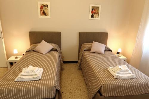 duas camas em um quarto de hotel com toalhas em Granny House em La Spezia