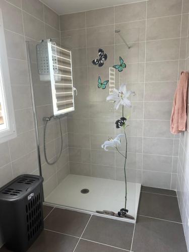 baño con ducha con mariposas en la pared en Chez Greg et Laëtitia2 