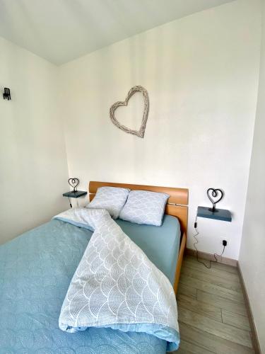 - une chambre dotée d'un lit avec un panneau cardiaque sur le mur dans l'établissement Jolie maison, jardin et parking, à Désertines