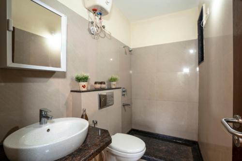 a bathroom with a white sink and a toilet at Goa Chillout Apartment - 1BHK, Baga in Baga
