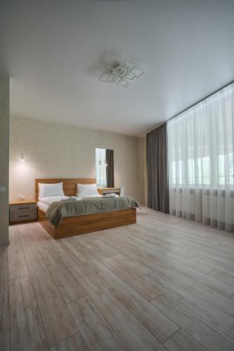 a large bedroom with a bed and a large window at Готель У Борисовича & SPA in Palyanytsya