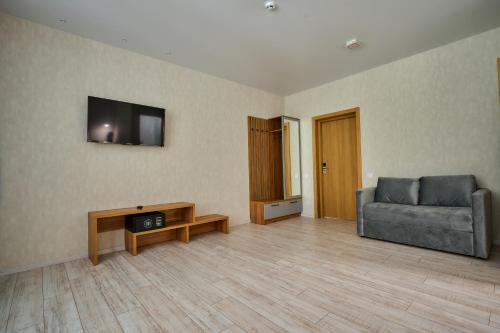 a living room with a couch and a tv on the wall at Готель У Борисовича & SPA in Palyanytsya
