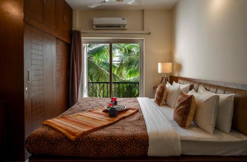 a bedroom with a bed with a tray on it at Goa Chillout Apartment - 1BHK, Baga in Baga