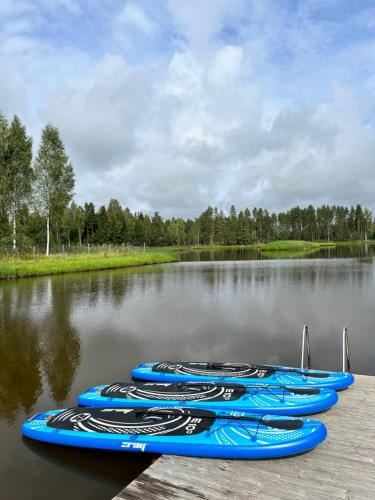 un gruppo di canoe blu sedute su un lago di Atpūtas vieta Jaunkārkliņi 