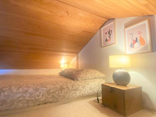 a bedroom with a bed and a wooden ceiling at Le chalet bucolique au bord de l'eau in Olivet