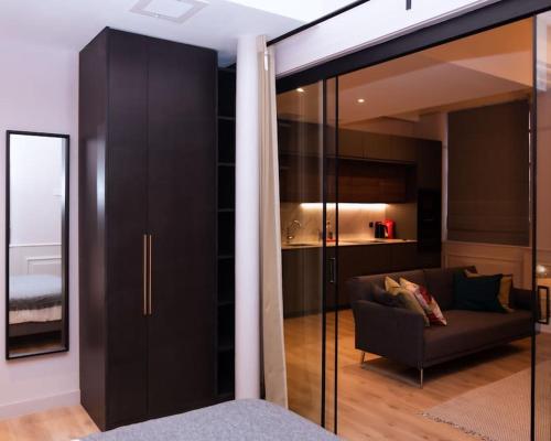 a living room with a couch and a glass wall at Luxurious stunning 2bedroom apartment in Manchester