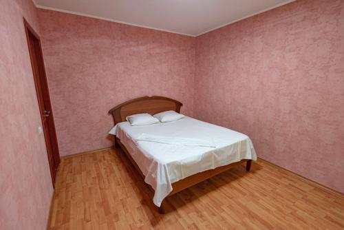 1 dormitorio con 1 cama en una habitación con paredes rosas en вулиця Митницька 55, en Cherkasy