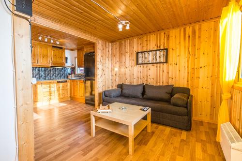 ein Wohnzimmer mit einem Sofa und einem Tisch in der Unterkunft Sandsjögården Holiday Resort in Blattniksele