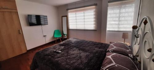 sypialnia z łóżkiem i telewizorem z płaskim ekranem w obiekcie Acogedor apartamento cerca del teleférico amarillo w mieście La Paz