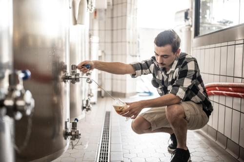 a man is sitting on a toilet in a bathroom stall at Hotel Restaurant Putzer in Naz-Sciaves