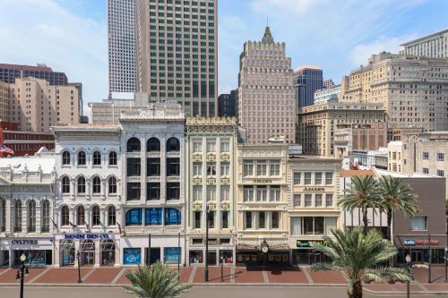 a city skyline with tall buildings and palm trees at Astor Crowne Plaza, Corner of Canal and Bourbon in New Orleans