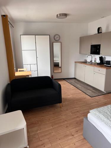 a living room with a black couch and a kitchen at City Appartement B - Zur ewigen Lampe dritte Etage in ein Historisches Denkmalschutz mit Garage in Brühl