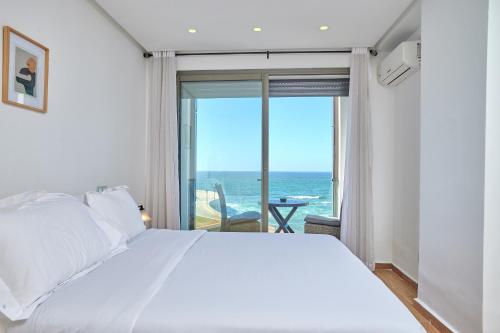 um quarto com uma cama e vista para o oceano em Apartment Sea View B23 - Mosquée Hassan II - By TheCasaEdition em Casablanca