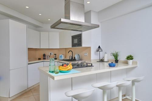 a kitchen with white cabinets and a bowl of fruit on a counter at Apartment Sea View B23 - Mosquée Hassan II - By TheCasaEdition in Casablanca