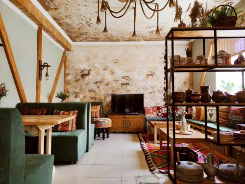 SilkRoad Guesthouse في بيشكيك: غرفة معيشة مع أريكة خضراء وطاولة