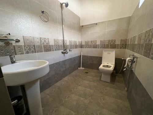 La salle de bains est pourvue d'un lavabo et de toilettes. dans l'établissement The Comfort Lodge, à Islamabad