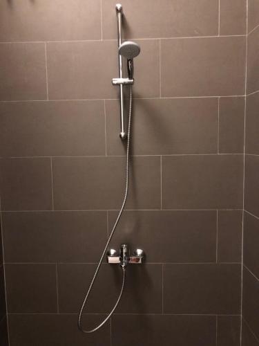 a shower with a shower head in a bathroom at OUTSIDE bungalow in Sekongkang