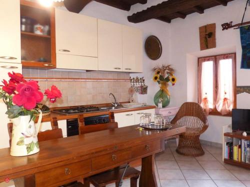 a kitchen with a wooden table with red flowers on it at Casa Marciana 2 - Isola D'Elba in Marciana