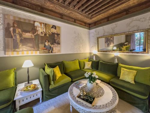 sala de estar con sofá verde y mesa en Maison Maria Palmeraie, en Marrakech