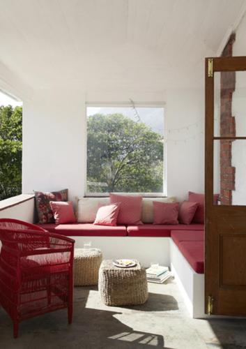 a living room with a red couch and a window at InAweStays Holiday Homes in Cape Town