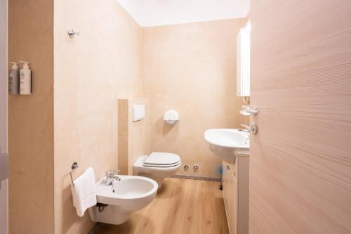 a bathroom with a white toilet and a sink at Hotel Vezza Alpine Lodge & Spa in Vezza dʼOglio