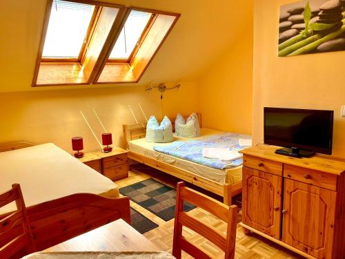 a small room with a bed and a tv at Pension zur Heiligen Krone in Mauterndorf