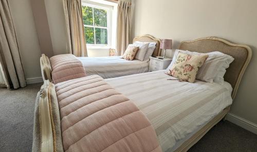 a bedroom with two beds and a window at Britannia House Vintage B&B Cornwall in Helston