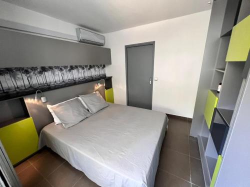 a small bedroom with a white bed in it at Ô LAGON in Saint-Gilles les Bains