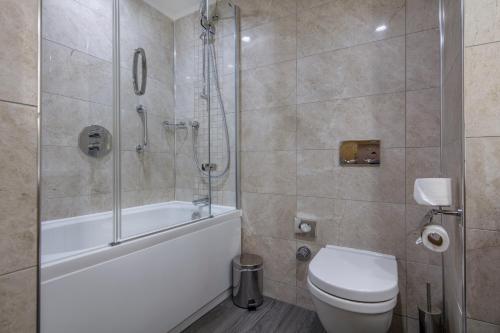 a bathroom with a tub and a toilet and a shower at Hilton Garden Inn Safranbolu in Safranbolu