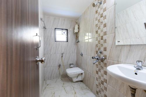 a bathroom with a toilet and a sink at Hotel Q Deck Rooms - Vile Parle Station and Near to Mumbai Airport in Mumbai