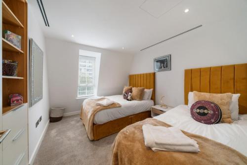- 2 lits dans une petite chambre aux murs blancs dans l'établissement Marble Arch Penthouse 3 Bed, à Londres