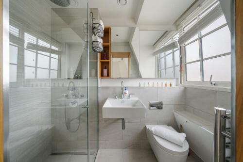 a white bathroom with a sink and a shower at Marble Arch Penthouse 3 Bed in London
