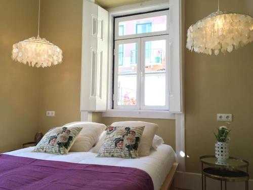 ein Schlafzimmer mit einem Bett mit zwei Kissen und einem Fenster in der Unterkunft SM2 Romantic HOME by the gardens PR Real & Bairro Alto in Lissabon