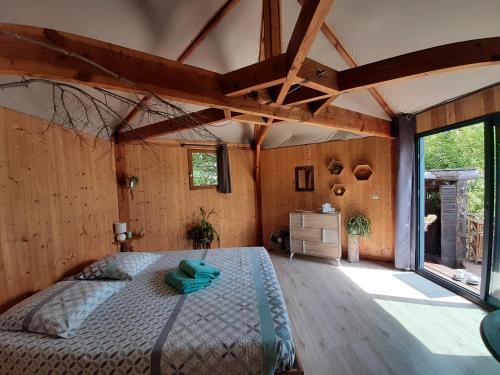a bedroom with a bed and a large window at la ruche in Grospierres
