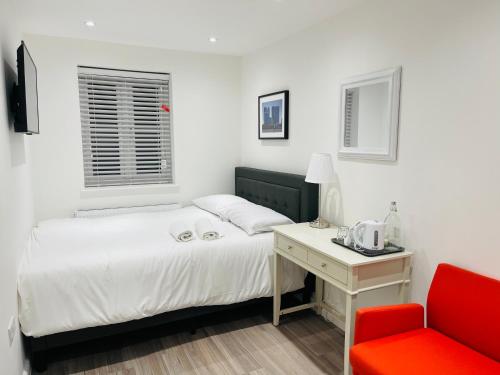 a bedroom with a bed and a red chair at Riverside Premium Double Room E14 in London
