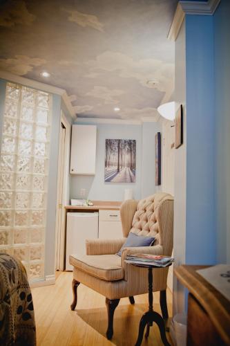 a living room with a chair and a table at Maison Des Jardins B & B in Montréal