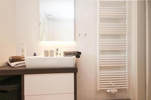 ein Bad mit einem Waschbecken und einem Spiegel in der Unterkunft Riff I in Norddeich