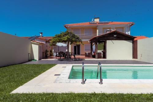 a house with a swimming pool in the yard at Retiro da Atafona Beach Pool House Yellow in Monte