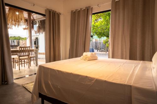 a bedroom with a large bed and a large window at Pousada Recanto da Paz in Caraíva
