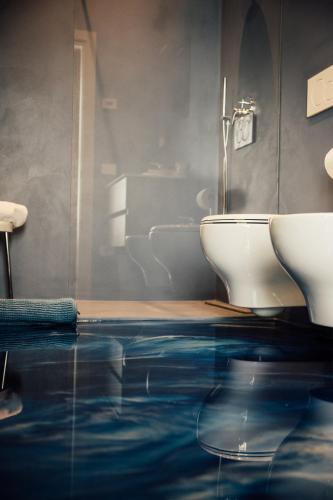 a bathroom with a blue floor and a toilet at Albergo La Meridiana in Castelnuovo del Garda