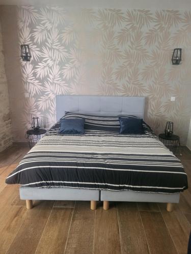 a white bed with blue pillows in a bedroom at Le Clos in Corcelles-les-Monts
