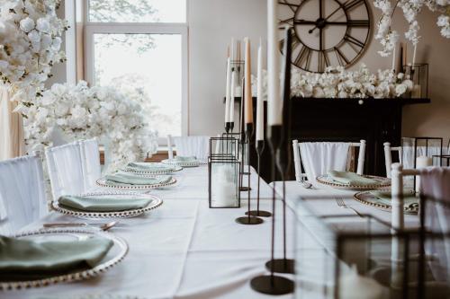 uma mesa branca com pratos e um relógio na parede em Morven Guest House Carnoustie em Carnoustie
