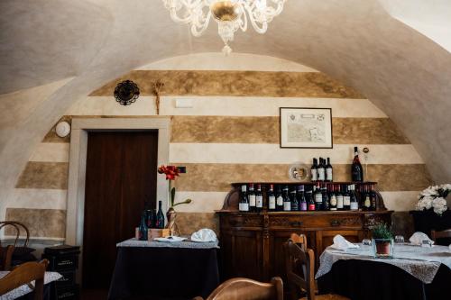 Habitación con 2 mesas y botellas de vino en Albergo La Meridiana, en Castelnuovo del Garda
