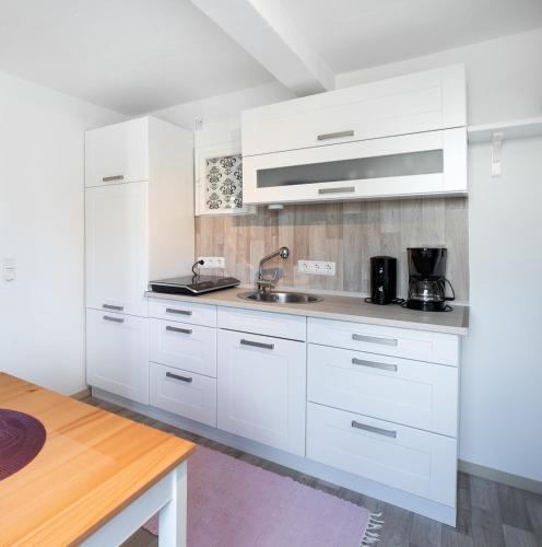 a kitchen with white cabinets and a sink at 2 Bett Ferienwohnung Rose in Westerburg
