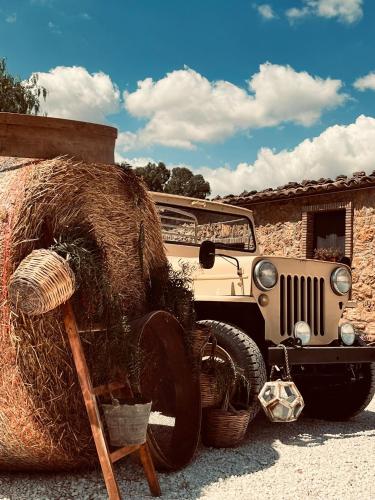 an old car parked next to a pile of hay at Agriturcostabaira in Caltagirone