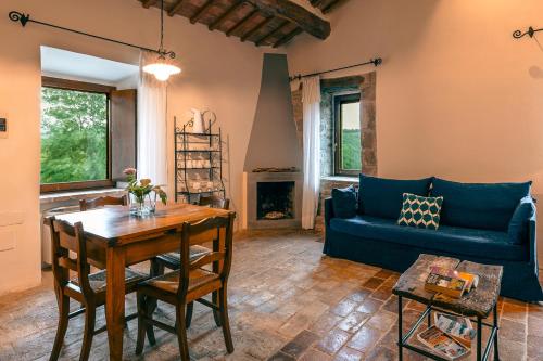 a living room with a blue couch and a table at Relais L'Antico Convento in Galera