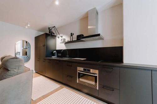 a kitchen with a counter with a sink and a stove at Chimay : La Chambre Rouge de la Grand Place in Chimay